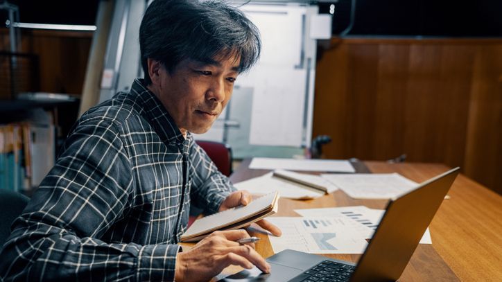 A man who's still saving for retirement looks over his self-directed IRA balance on his laptop.